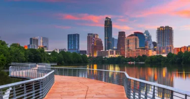 Austin skyline with tall buildings and water from bridge at dusk